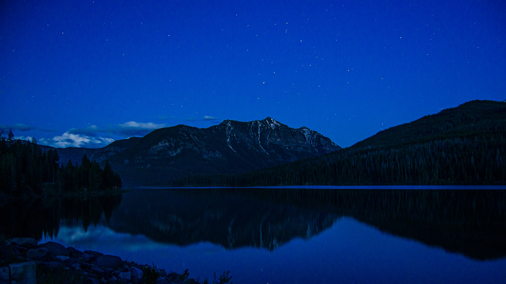 Night sky over peaks reflecting on Hyalite Reservoir near Bozeman, Montana